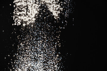 Abstract black and white background of pouring flour, space for text