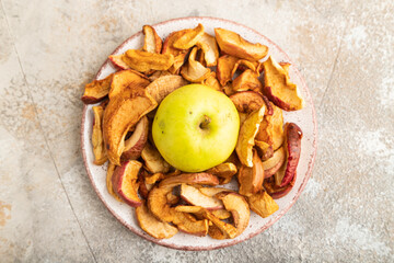 Dried Apples in ceramic bowl on brown concrete. Top view, close up