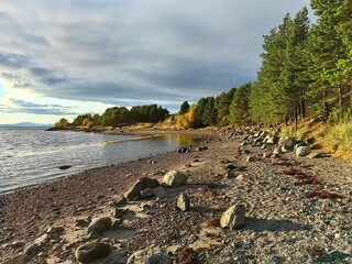 Vibrant shoreline along the White Sea in Kandalaksha, Murmansk region during golden hour. Kola Peninsula