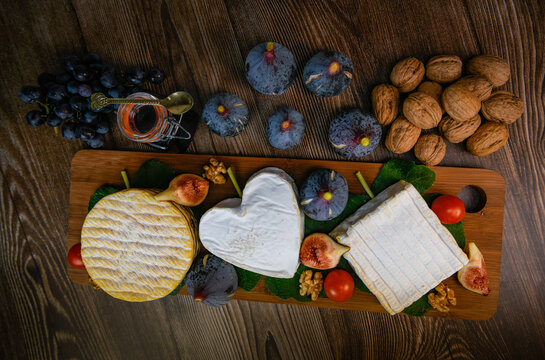 Selection of French cheeses from Normandy, AOP, Livarot, Neufchatel, Pont l'eveque, Rye bread, figs, walnuts, grapes, elderberry gelee. High quality photo