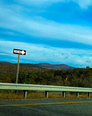 One way sign : Signage on the street with colorful mountains in the background, fall foliage in...