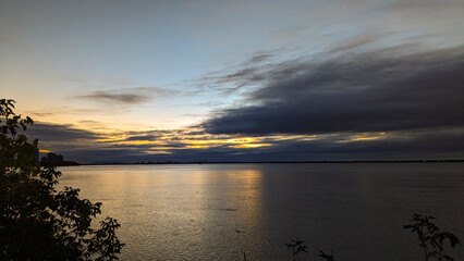 Cloudy Sunrise Casting Soft Yellow Hues Over the River on a Summer Morning