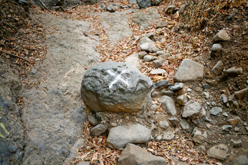 stone with cross mark showing wrong way on the footpath
