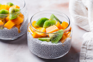 Chia pudding with mango and kiwi in jar. Vegan breakfast concept.