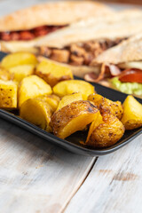 Tray of potato wedges with sandwiches on the background