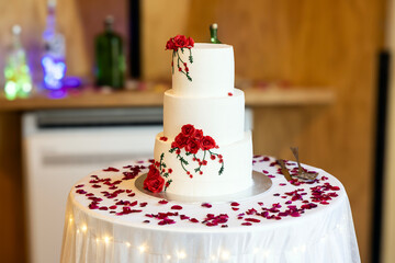 A beautifully decorated wedding hall featuring elegant tables, with a stunning wedding cake as the centerpiece, ready for celebration.