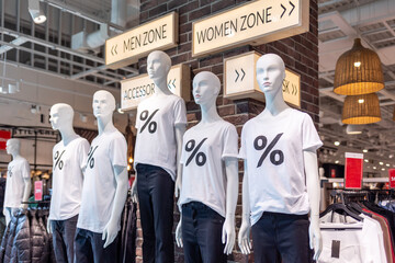 Black Friday and Cyber Monday. White mannequins with white T-shirts with a percentage symbol on. The concept of seasonal sales and discounts. Shopping and consumerism