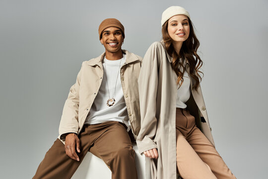 A trendy couple enjoys a playful moment wearing colorful autumn outfits that shine with style.