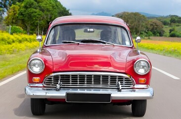 Red vintage car driving on road