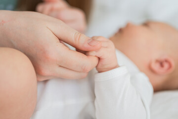 Happy family. Tiny newborn infant baby little hand on mother hand palm. Newborn baby holding parent...