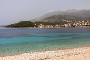 Panoramic view of the picturesque coastline of coastal tourist town Himare, Vlore, Albania. Sand beach Potami with scenic vistas of majestic mountains of Karaburun-Sazan Marine Park. Summer vacation