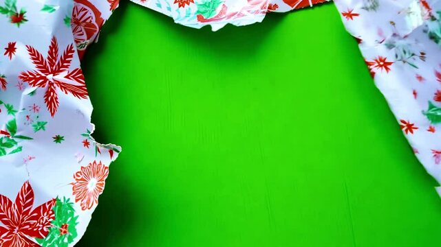 Unwrapping Christmas wrapping paper on green screen. Unwrapping gift revealing a green screen. Craft paper gift wrapping, Christmas holiday concept. Copy space
