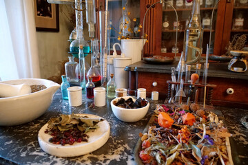 Chemistry flasks with liquids, herbs of medicinal plants in an old pharmacy