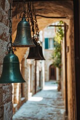 Old bells in a sunlit stone alley create a nostalgic atmosphere.