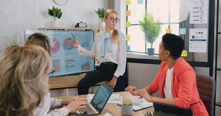 Woman manager holding meeting for business women shows statistical graphs and charts in office