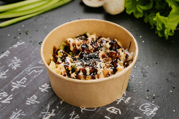 Delicious poke bowl with rice, grilled chicken, vegetables, sesame seeds, and creamy dressing