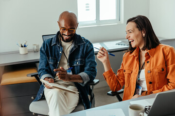 Diverse business colleagues having a joyful discussion during an office meeting