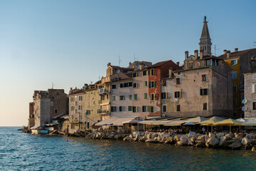 Fototapeta premium Basking in the golden sunlight along the waterfront of Rovinj, Croatia, during a serene evening