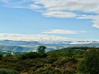 Expansive View of Rolling Hills and Verdant Valleys in Auvergne-Rh&ocirc;ne-Alpes from Aire de Lafayette Lorlanges, Highlighting Lush Vegetation and Dramatic Cloudscapes Along the A75 Motorway