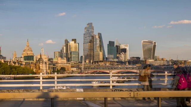 Sunset time lapse view of the London skyline with blurred motion business people commuting from work in front