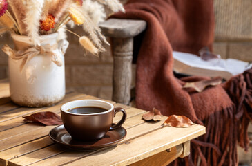 Cup of coffee on wooden table outdoors on porch