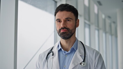 Professional doctor standing hospital hallway closeup. Serious bearded physician