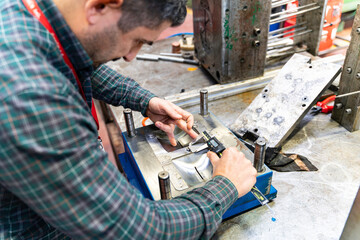 Lathe worker man working with a vernier and milling machine in a factory, using a caliper to check measurement.