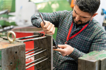 Lathe worker man working with a vernier and milling machine in a factory, using a caliper to check measurement.