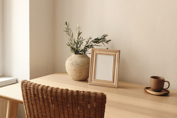 Elegant artistic mockup template. Black vertical photo frame on wooden table desk. Vase with olive...