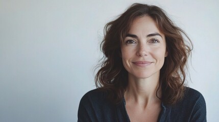 Fototapeta premium Warm Portrait of a Smiling Woman Against Neutral Background