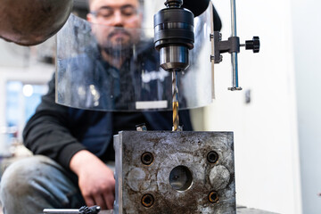 Lathe worker man working with a vernier and milling machine in a factory, using a caliper to check measurement.