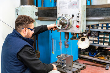 Lathe worker man working with a vernier and milling machine in a factory, using a caliper to check measurement.