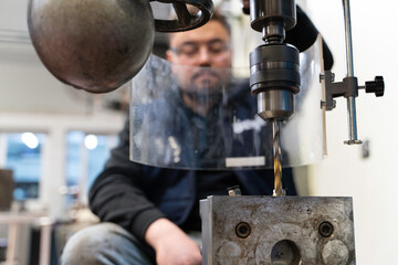 Lathe worker man working with a vernier and milling machine in a factory, using a caliper to check measurement.