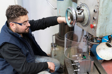 Lathe worker man working with a vernier and milling machine in a factory, using a caliper to check measurement.