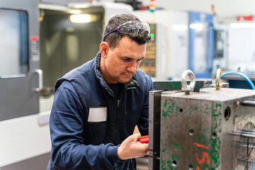 Lathe worker man working with a vernier and milling machine in a factory, using a caliper to check measurement.