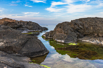 Landscape rocky shore by the black sea. Stagnant water in the rocks. Reflection in the water. Ahtopol, Bulgaria.