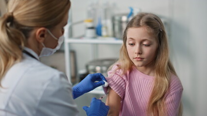 Obraz premium Closeup nurse giving vaccine injection in clinic. Childcare and immunization