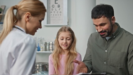 Fototapeta premium Smiling girl visiting therapist with father closeup. Happy doctor give high five
