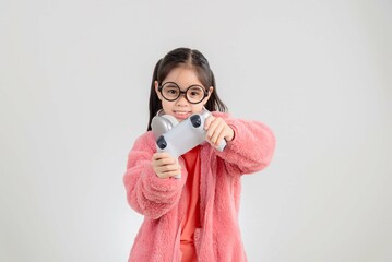 Fototapeta premium Asian happy portrait young kid girl smile lifestyle games technology holding joystick game playing on hands studio shot isolated white background with copy space.