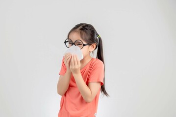 Asian child girl sick with sneezing on the nose and cold cough on tissue paper because weak or virus and bacteria from dust weather