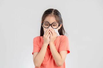 Asian child girl sick with sneezing on the nose and cold cough on tissue paper because weak or virus and bacteria from dust weather