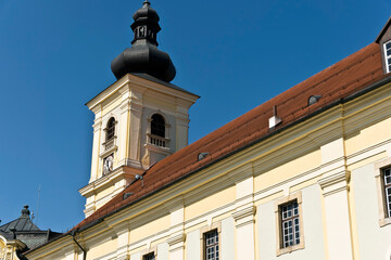 A baroque-style church tower in Sibiu, Romania, featuring an onion-shaped dome, a clock face, and arched windows.