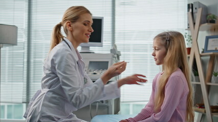 Medical worker consulting kid during appointment. Closeup cheerful young patient