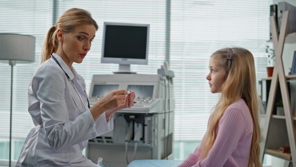 Obraz premium Smiling pediatrician giving high five to cute girl. Closeup child visit doctor