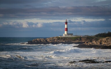Obraz premium Coastal lighthouse seascape. A majestic lighthouse stands tall against the crashing waves, symbolizing hope and guidance amidst the stormy sea.