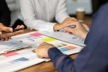 Businessman meeting with consultants discussing data analysis, charts and graphs in financial reports to plan investments and increase company profits.