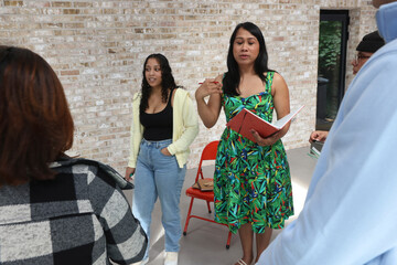 Woman dressed in green dress, holding notebook during meeting