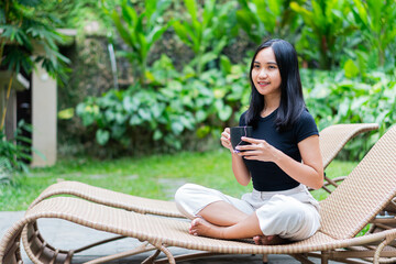 Young Woman Relaxing in Garden with Coffee