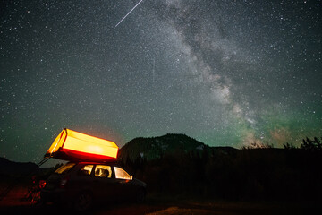 the Milky Way in the starry sky above a motorhome in the Altai mountains