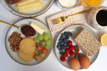 Assortment of various breakfast foods and drinks on the white table. Flat lay.